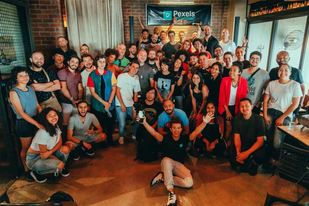 A large group of diverse colleagues celebrating together indoors, with smiles and positive energy.