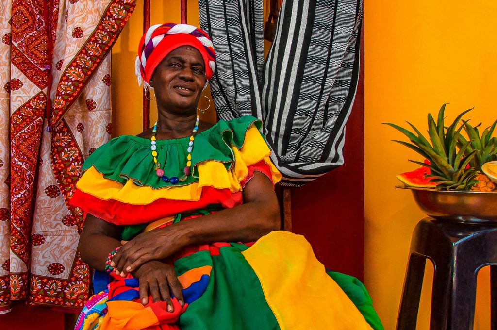 Elegant mature woman in colorful dress and turban in Cartagena, Colombia.