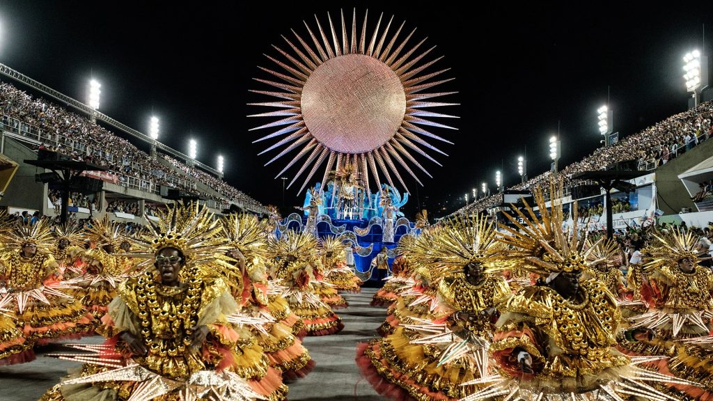 Samba dancers in vibrant costumes performing during the Rio Carnival parade at the Sambadrome in Brazil.